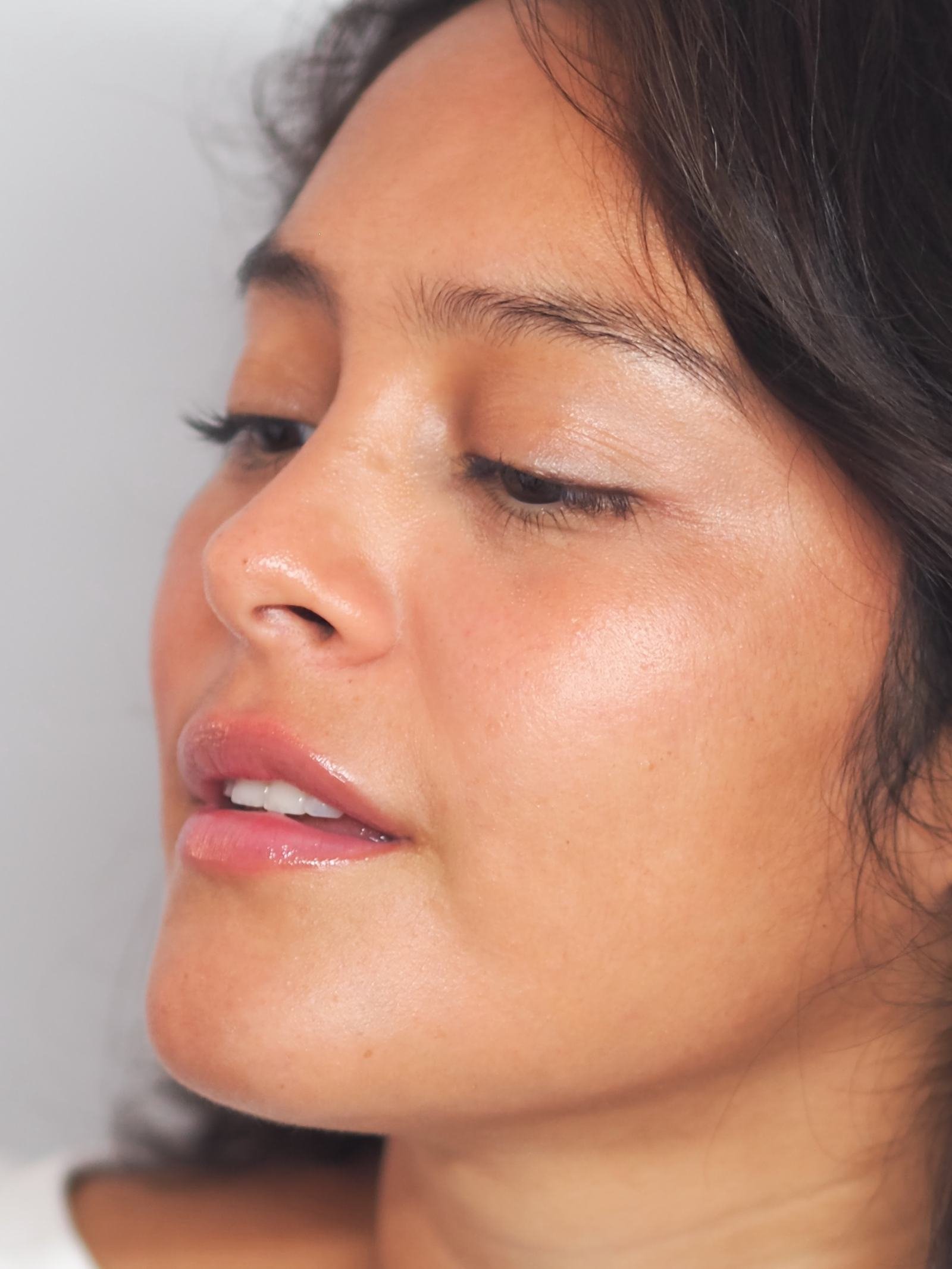 Visage d’une femme de trois quarts, regard baissé, peau naturelle